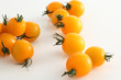 gelbe Kirschtomaten auf weissem Acryl mit Wassertropfen