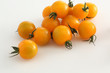 gelbe Kirschtomaten auf weissem Acryl mit Wassertropfen