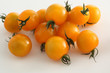 gelbe Kirschtomaten auf weissem Acryl mit Wassertropfen