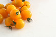 gelbe Kirschtomaten auf weissem Acryl mit Wassertropfen