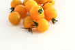 gelbe Kirschtomaten auf weissem Acryl mit Wassertropfen