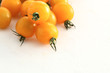 gelbe Kirschtomaten auf weissem Acryl mit Wassertropfen