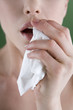 A young woman sneezing
