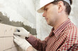 Man installs ceramic tile on a wall