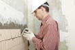 Man installs ceramic tile on a wall