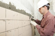 Man installs ceramic tile on a wall