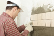 Man installs ceramic tile on a wall