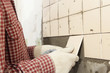 Man installs ceramic tile on a wall