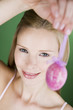 A portrait of a young blonde woman holding a pink Easter egg