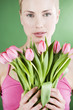 A young woman holding a bunch of pink tulips