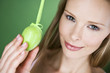 A young blonde woman holding a green Easter egg, close-up