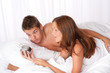 Young man watching alarm clock in the morning