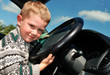 joyful little boy at driver position in a car joyful little boy at driver position in a car