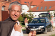 Handsome mature businessman standing before house