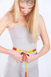 Measure tape around slim woman's waist