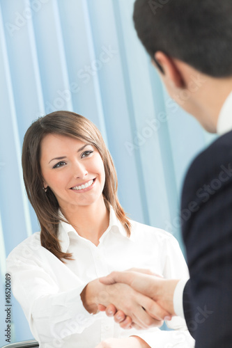 Foto: Businesspeople, or businessperson and client handshaking Businesspeople, or businessperson and client handshaking