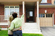 Happy couple in front of home