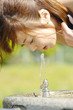 公園の水を飲む女性