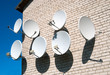 Seven satellite dish on the white wall Seven satellite dish on the white wall
