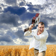 man smashing guitar cloudy sky