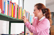 Young teacher picking up a book