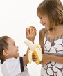 Photo: Two young kids have fun while eating fresh fruit. Two young kids have fun while eating fresh fruit.