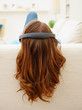 Rear view of a female hearing music while lying on the couch, fo