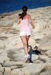 Woman running along rocks