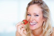 Closeup portrait of a young girl eating a strawberry
