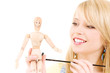 happy teenage girl with wooden model dummy