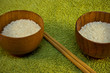 bowls with rice and sticks on green bowls with rice and sticks on green