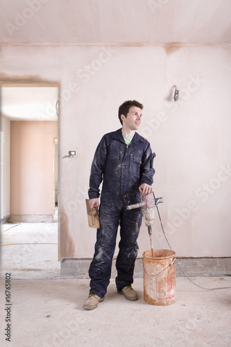 Photo: Man mixing plaster in house under construction Man mixing plaster in house under construction
