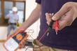 Close up of electrician holding voltmeter