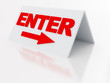 sign enter with arrow on a light plastic tablet