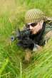 Sniper laying in a grass. ASG battle. Focus on a face.