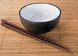 Photo: Chopsticks with ceramic bowl on bamboo mat Chopsticks with ceramic bowl on bamboo mat