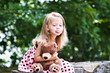 Child holding her teddy tightly and sticking out her tongue.