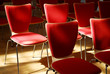 many red chairs standing in a row with