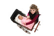 young girl lifting doll from antique baby carriage