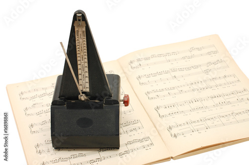 Foto: metronome on sheet music background metronome on sheet music background