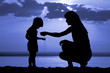 Silhouette of women to pour sand in hand child on moon night Silhouette of women to pour sand in hand child on moon night