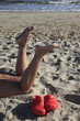 Foto: nackte Beine eines Mädchen am Sandstrand mit roten Crocs nackte Beine eines Mädchen am Sandstrand mit roten Crocs