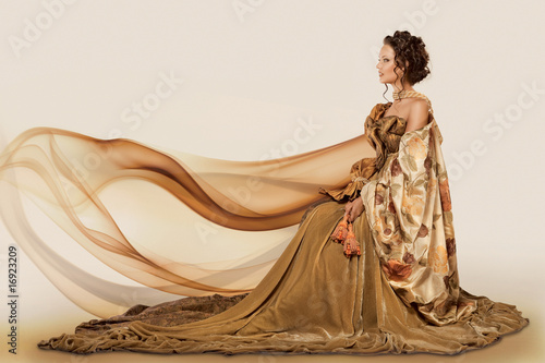 Photo: Woman sitting in a formal full flowing gown Woman sitting in a formal full flowing gown