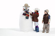 Isolated young boy & girl finishing snowman Isolated young boy & girl finishing snowman