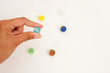 Fingers Holding a Glass Marble with Others in the Background