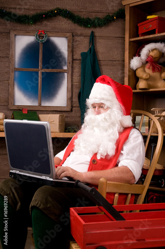 Photo: Santa Claus in Workshop Using Laptop Santa Claus in Workshop Using Laptop