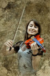 Beautiful female violinist playing violin on the grunge backgrou