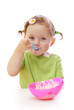 Baby girl eating yoghurt isolated on white background