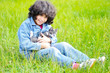 Very cute little girl with cat on meadow