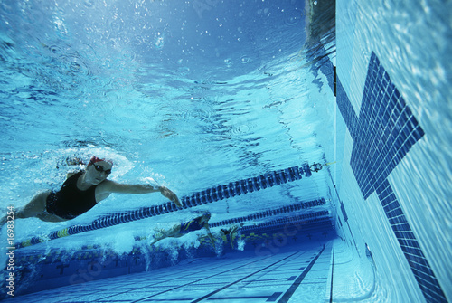 Photo: Underwater view of swimmers in pool Underwater view of swimmers in pool